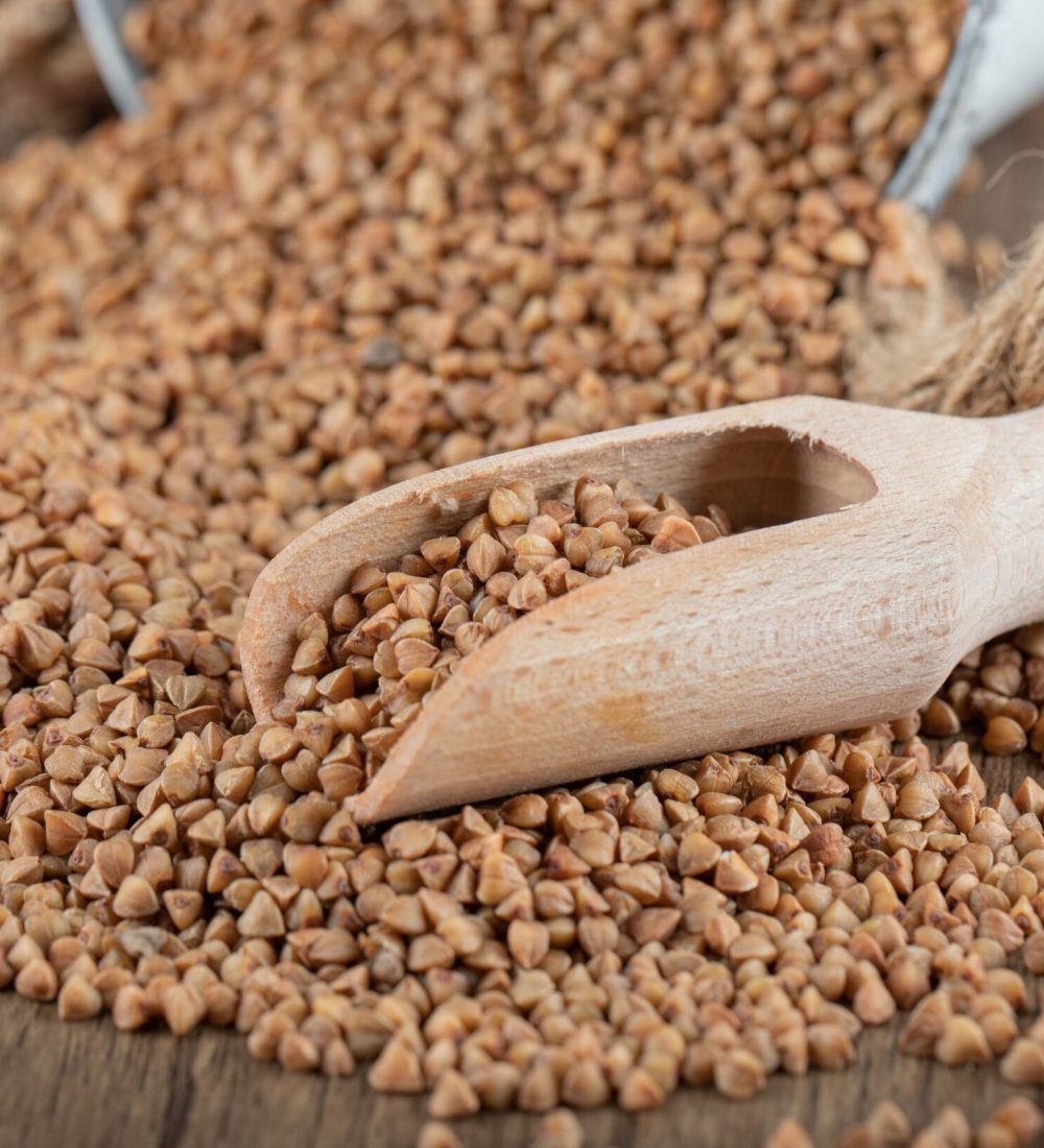 Pile of uncooked buckwheat on wooden spoon. High quality photo